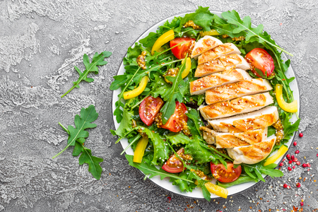 Chicken salad. Meat salad with fresh tomato, sweet pepper, arugula and grilled chicken breast. Chicken fillet with fresh vegetable saladの写真素材