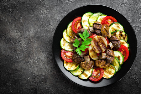 Salad with fresh and grilled vegetables and mushrooms. Vegetable salad with grilled champignons. Vegetable salad on plateの写真素材