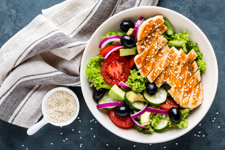 Grilled chicken breast with fresh vegetable saladの写真素材