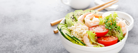 Hawaiian poke bowl with shrimps, rice and vegetables, healthy Buddha bowl with prawns, rice, avocado, cucumber, tomato and lettuce. Bannerの写真素材