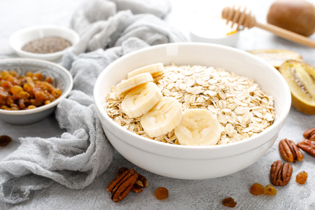 Oat flakes with fruits, nuts and honey in bowl