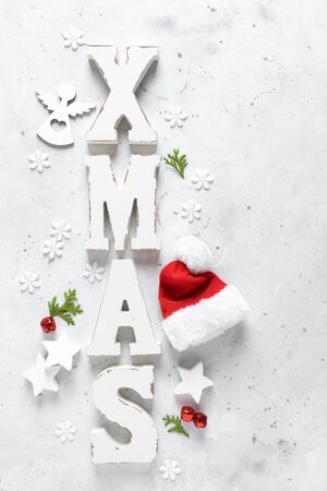Christmas, New Year or Noel holiday festive winter greeting card with decorations,  X-mas ornaments, stars, snowflakes, santa hat and Xmas bells on white background, flat lay composition, top view, copy spaceの写真素材
