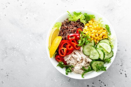 Chicken meat lunch bowl with fresh salad leaves, corn, cucumber, sweet pepper and quinoaの写真素材