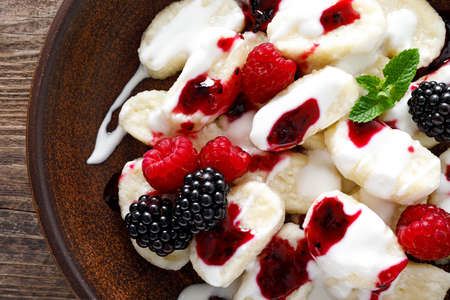 Lazy dumplings, vareniki with fresh berries. Boiled cottage cheese gnocchi with sour cream, raspberry and blackberry. Traditional ukrainian cuisineの写真素材