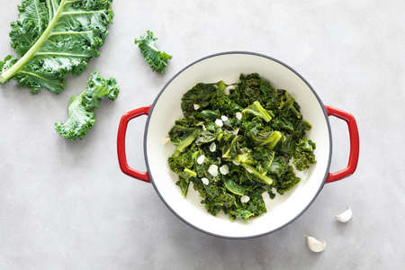 Sauteed kale with garlic in cast iron pan on kitchen table, healthy food concept, superfoodの写真素材