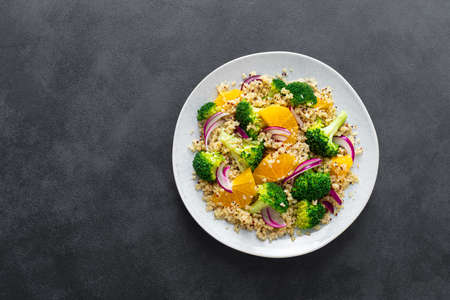 Vegan quinoa and broccoli warm salad with oranges and fresh onion, top down viewの写真素材