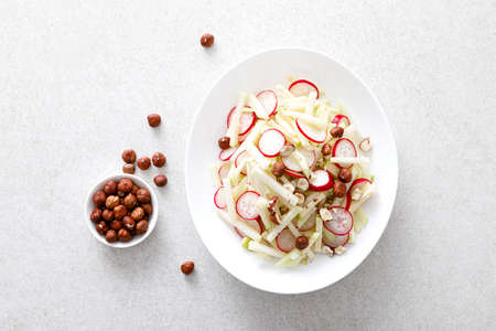Fresh fruit and vegetable salad with kohlrabi, green apple, radish and hazelnutsの写真素材