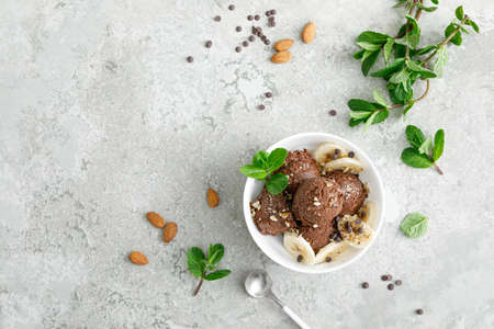 Chocolate and banana fruit ice cream with almond nuts served in bowls, top view