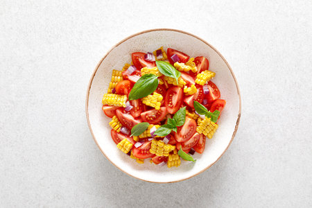 Tomato and corn salad with fresh basil and red onionの写真素材