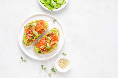 Open sandwiches with salted salmon, guacamole avocado and microgreens. Seafood. Healthy food. Top view.の写真素材