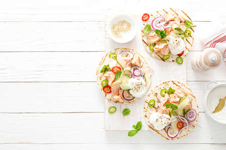 Spicy tacos with grilled salmon, vegetables, ricotta cheese, chili and fresh mintの写真素材