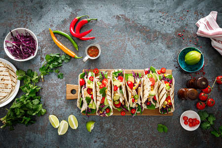 Chicken tacos with grilled meat, avocado, fresh vegetable salad and sauce salsaの写真素材