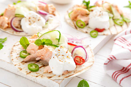 Spicy tacos with grilled salmon, vegetables, ricotta cheese, chili and fresh mintの写真素材