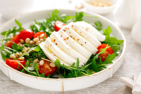 Salad with arugula, mozzarella cheese and pine nuts. Breakfast. Ketogenic, keto or paleo diet. Healthy foodの写真素材