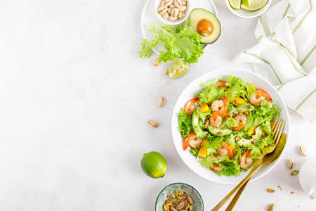 Grilled shrimp salad with avocado, mango, lettuce and pistachios, dressed with lime. Healthy food. Ketogenic diet. Top view.の写真素材