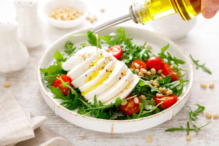 Salad with arugula, mozzarella cheese and pine nuts. Breakfast. Ketogenic, keto or paleo diet. Healthy foodの写真素材
