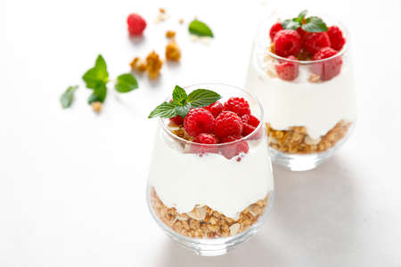 Granola with white plain yogurt and raspberry in a glassの写真素材