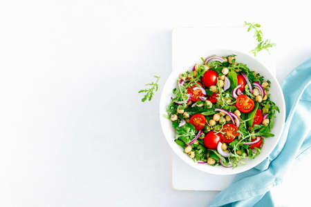 Vegetarian chickpea salad with tomatoes, arugula, parsley, spinach and red onion. Healthy food, diet. Top viewの写真素材