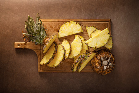 Pineapple. Sliced pineapple on brown background, top viewの写真素材