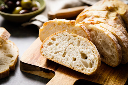 Ciabatta bread sliced on a board, top view