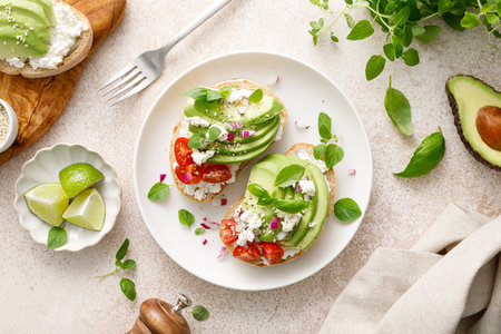 Avocado toast with cheese cottage, tomato and herbs for breakfastの写真素材