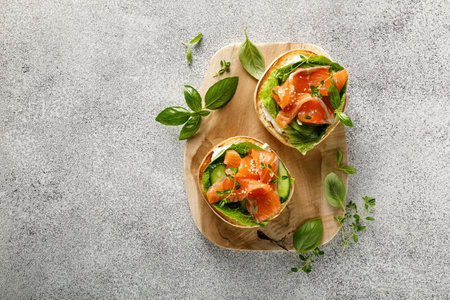 Salmon sandwiches with cream cheese, fresh romaine lettuce and cucumber, top down view