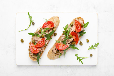 Tuna caper toasts with arugula, tomatoes and whole rye bread, top viewの写真素材