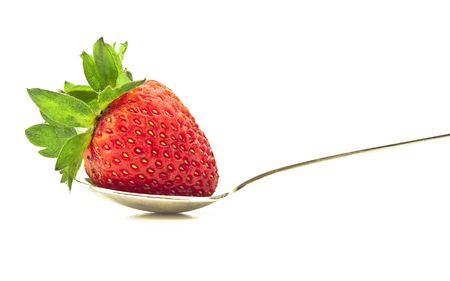 Ripe strawberry on a spoon with a white backgroundの写真素材
