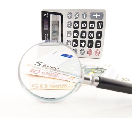 The calculator, money and magnifying glass - objects for economic calculationsの写真素材