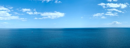 Panorama of a sea landscape with white clouds and the quiet  blue waterの写真素材