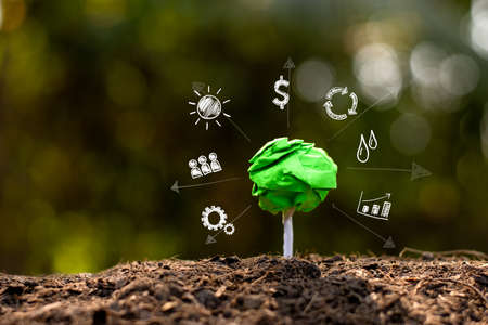 Green recyclable paper trees on the ground and there are technology icons around, Environmental concepts.の写真素材