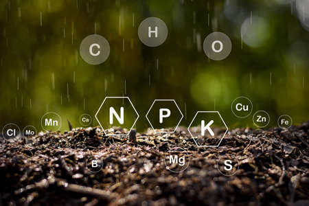 Soil rich in minerals for cultivation while rain droplets are scattered and technology icons are around.の写真素材