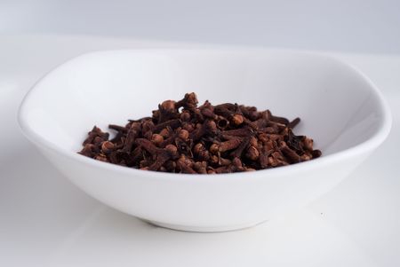 A white bowl with a heap of clovesの写真素材