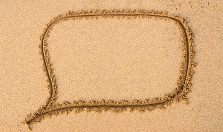 A speech bubble drawn out on a sandy beachの写真素材