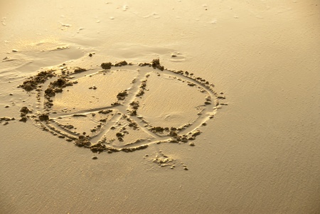 A peace sign written on the beach - being washed away.の写真素材
