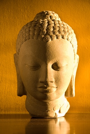 A statue of Buddha against a yellow backgroundの写真素材