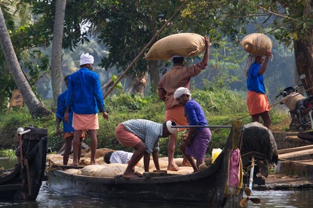 ALLEPPEY, KERALA, INDIA, MARCH 31, 2015: Some men transport, overload, put on them head dwell of riceのeditorial素材