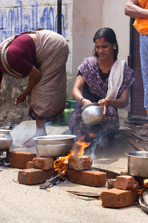 KOVALAM, KERALA, INDIA, April 1, 2015: Some women devotees participate in Pongala ceremony where boiled rice made in clay pots is offered to the godのeditorial素材