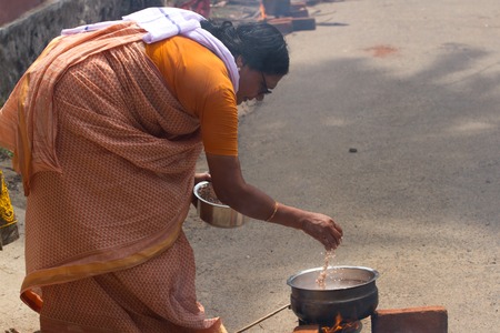 KOVALAM, KERALA, INDIA, April 1, 2015: Some women devotees participate in Pongala ceremony where boiled rice made in clay pots is offered to the godのeditorial素材