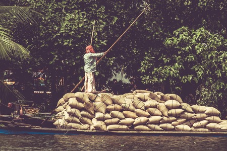 Allepey, Kerala, India March 31, 2015: Indian man transport dwell with rice for boats. backwaters canoe in state,.のeditorial素材