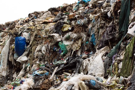 Pile of plastic bags and other refined petroleum products dumped in landfill. Garbage heap gives...