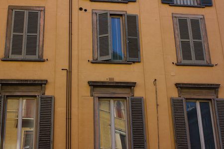 Many windows. Medieval facade. Window shutters. Architectural style of Italyの写真素材