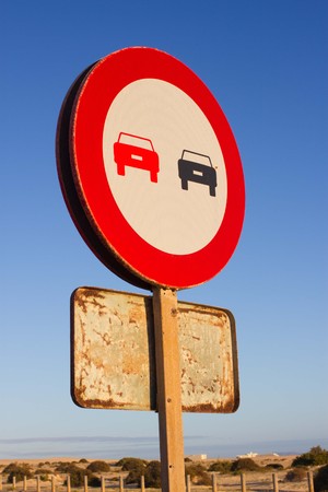 No overtaking. Prohibited to advance indicating. Round red traffic sign. Ocean road. Asphalt.の写真素材