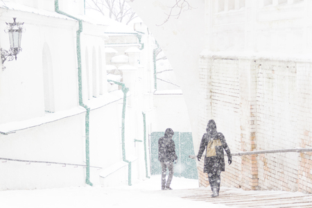 People walking at street way down. Snow storm freezeの写真素材