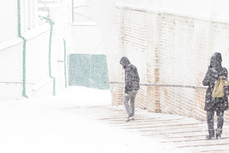 People walking at street way down. Snow storm freezeの写真素材
