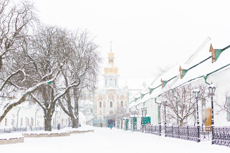 Entrance gate of the Pechersk Lavra in Kiev, Ukraine. The Gate Church of the Trinity in winter snow stormの写真素材