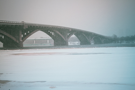 View of the Metro bridge and Dnieper river in dense fog, big snow storm, misty landscape, Kyiv the capital of Ukraine, Eastern Europeの写真素材
