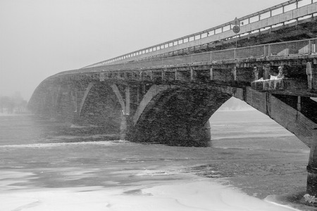 Kyiv Metro bridge . Winter urban landscape in big snow storm. Poor visibility. Kiev, Ukraine. White and black photographyの写真素材