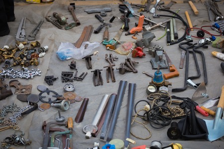 Old metal tools wrench, key, pliers lying on the asphalts at flea market in Kiev, Ukraineの写真素材