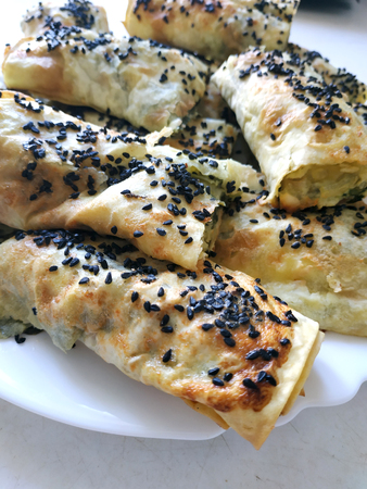 Homemade prepared cutted lavash pieces with vegetables. Burek with spinach and cheese and black cumin. Yufkaの写真素材